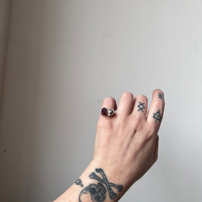 Silver skull and garnet ring with decorative flowers by Charlie Shires jewellery
