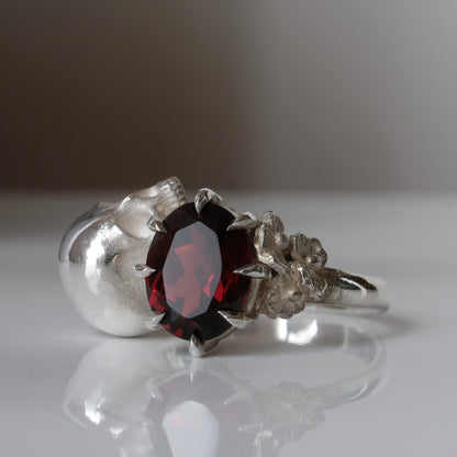 Silver skull and garnet ring with decorative flowers by Charlie Shires jewellery