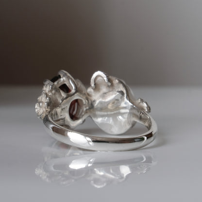 Silver skull and garnet ring with decorative flowers by Charlie Shires jewellery