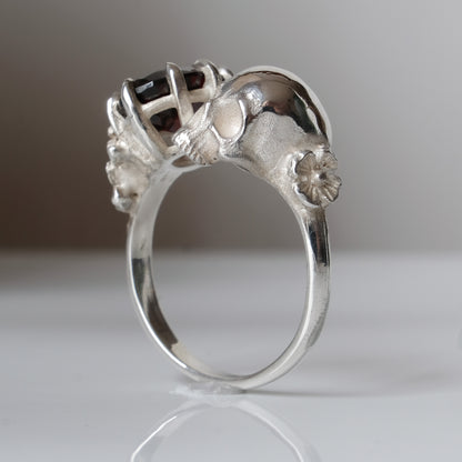 Silver skull and garnet ring with decorative flowers by Charlie Shires jewellery