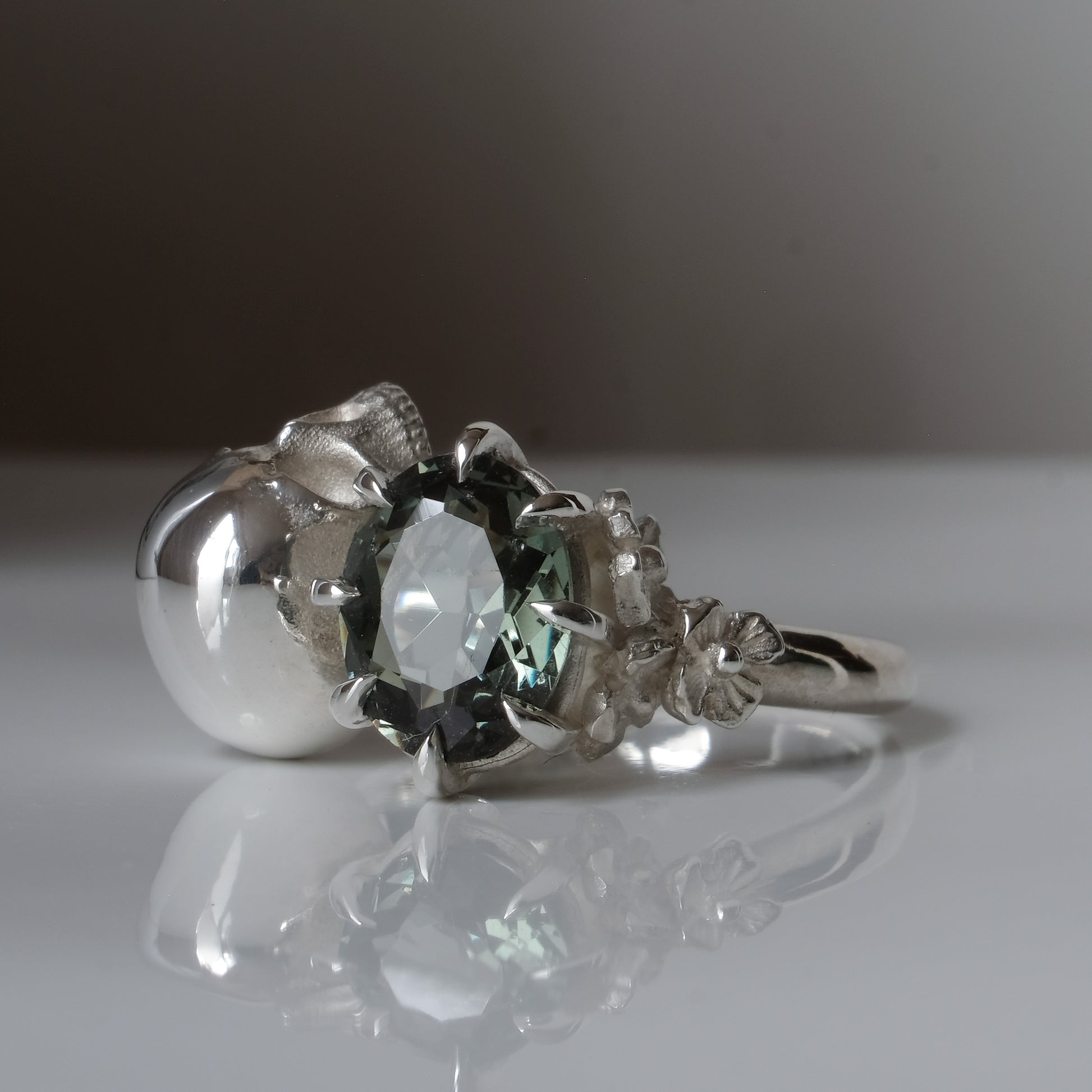 Silver skull and synthetic tourmaline ring with decorative flowers