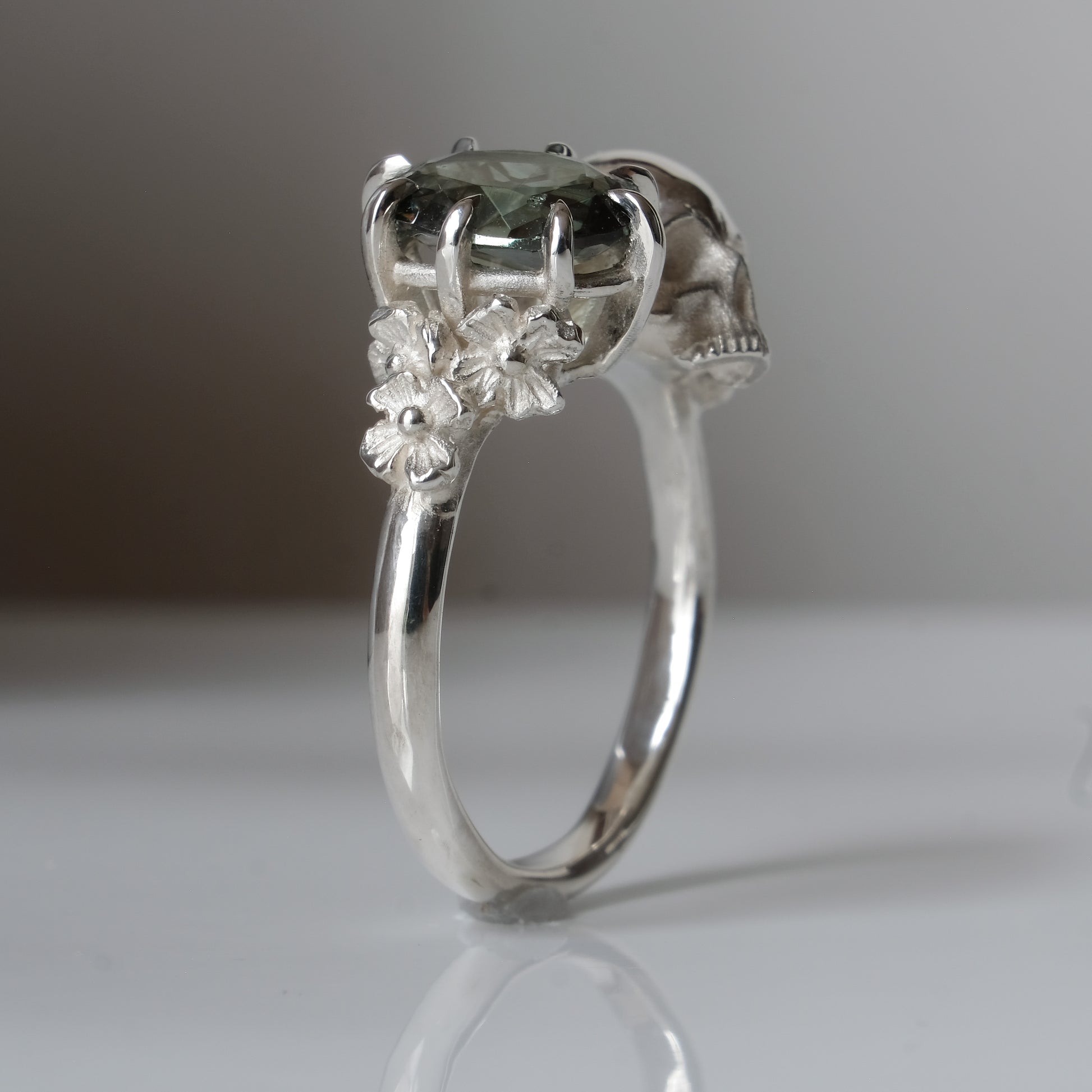 Silver skull and synthetic tourmaline ring with decorative flowers