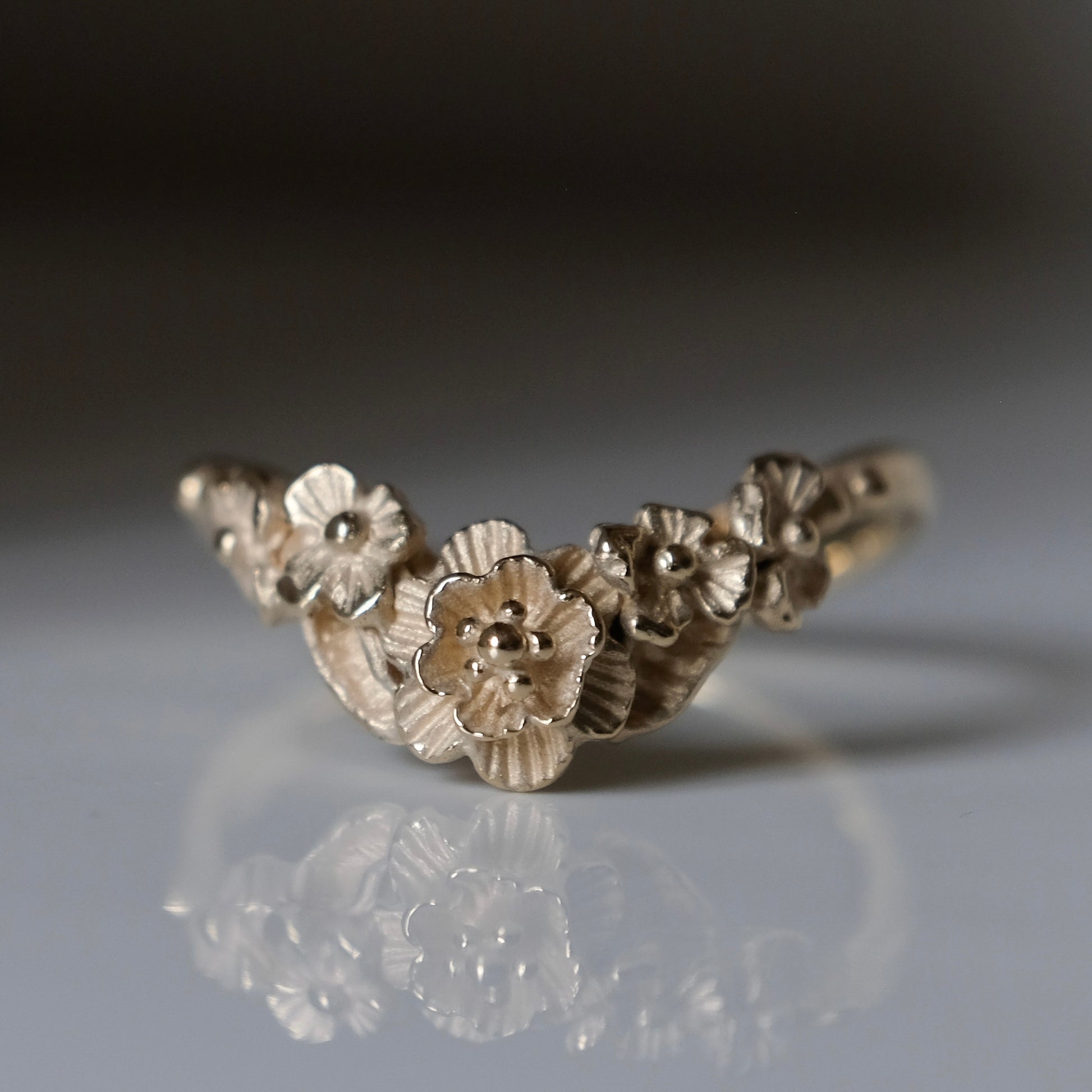 Wishbone shaped stack ring decorated with flowers and leaves. Made in London in 9ct yellow gold by Charlie Shires