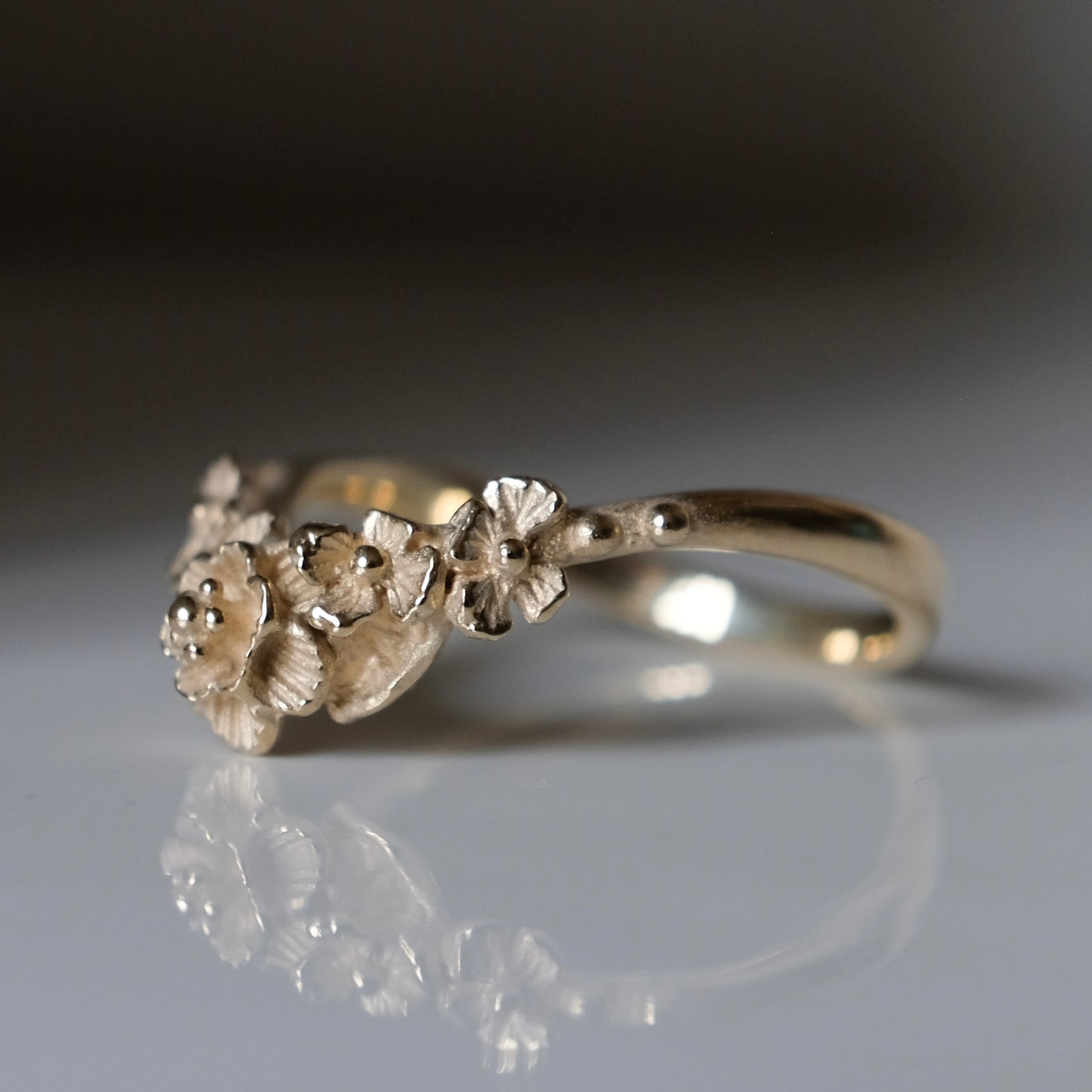 Wishbone shaped stack ring decorated with flowers and leaves. Made in London in 9ct yellow gold by Charlie Shires