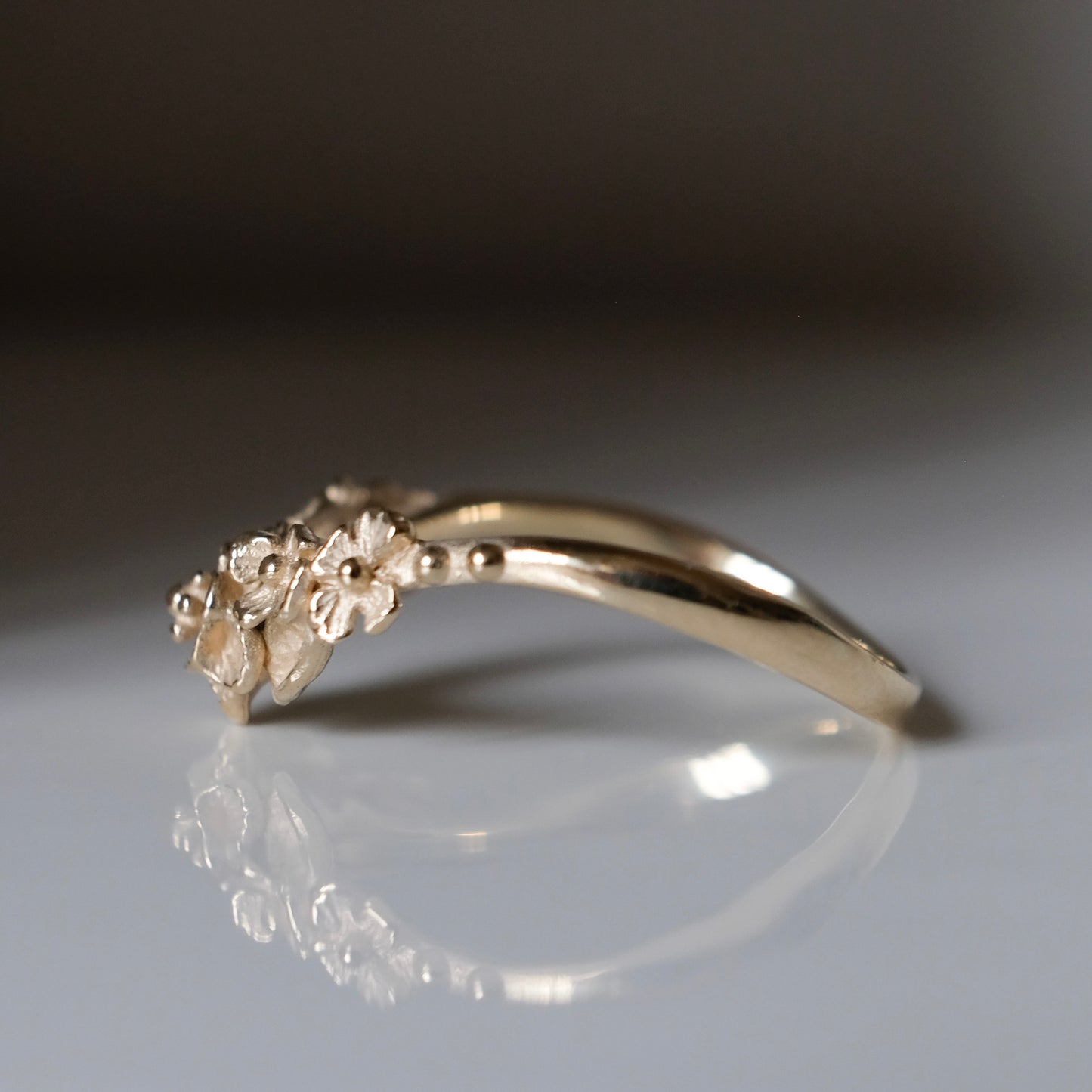 Wishbone shaped stack ring decorated with flowers and leaves. Made in London in 9ct yellow gold by Charlie Shires