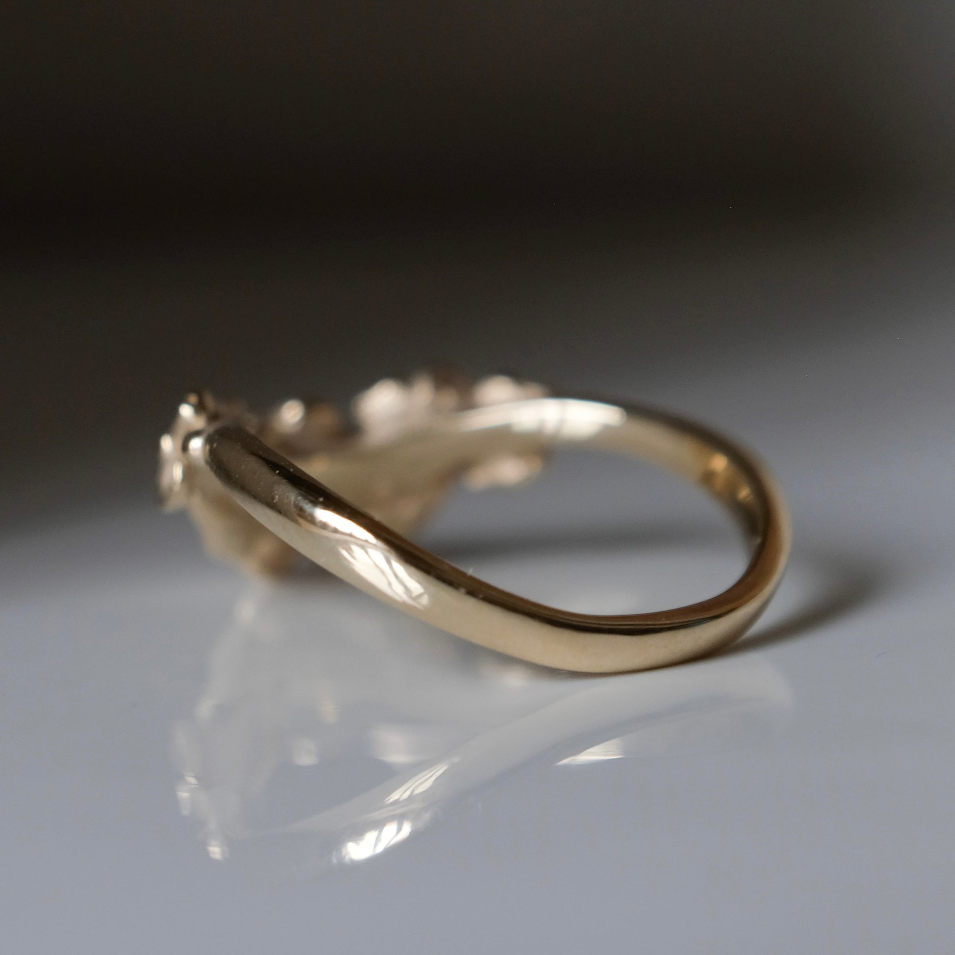 Wishbone shaped stack ring decorated with flowers and leaves. Made in London in 9ct yellow gold by Charlie Shires