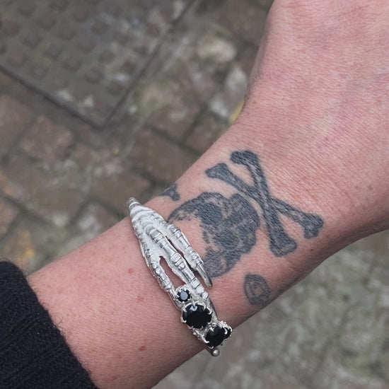 Sterling silver birds claw talon bangle handmade with black spinel stones and flowers in London by Charlie Shires