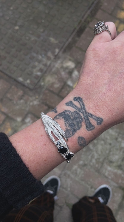 Sterling silver birds claw talon bangle handmade with black spinel stones and flowers in London by Charlie Shires